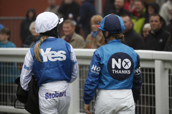 Jockeys Carol Bartley (right) and Rachel Grant pose for photographs in pro-independence “Yes” campaign colors, and anti-independence“No” campaign colors before racing at Musselburgh racecourse, in a publicity event arranged by Ladbrokes Plc. in Edinburgh on Monday. (Bloomberg)