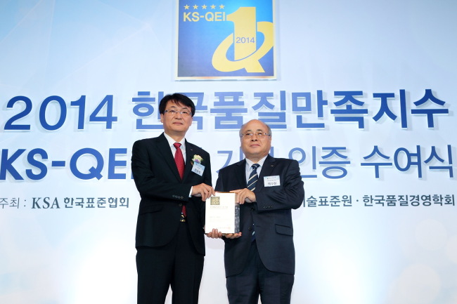 KT marketing executive Han Jun-seok (left) poses after the company was recognized for its superb mobile and Internet services Thursday. (KT)