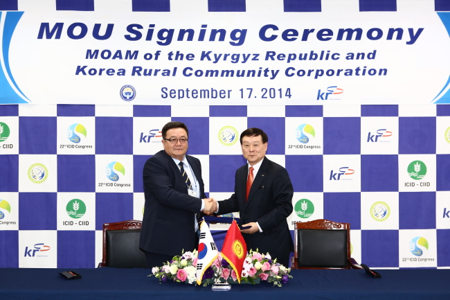 Lee Sang-mu (right), president of Korea Rural Community Corp., and Kyrgyz Republic’s Agriculture Minister Aidaraliev Taalaibek shake hands after signing an MOU to improve the agriculture partnership between the two nations. (Yonhap)