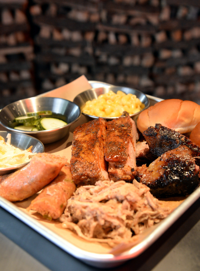 Holy Smoke’s meat platter features two ribs, 100 grams each of sausage, brisket and pulled pork, and a choice of three sides. (Ahn Hoon/The Korea Herald)