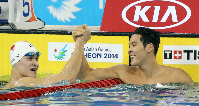 South Korean swimmer Park Tae-hwan (right) holds the hand of Sun Yang of China after finishing third in the men’s 200 m freestyle final at the Incheon Asian Games on Sunday. Yonhap