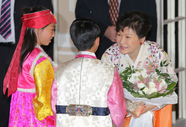 President Park Geun-hye (far right) receives flowers from children before her meeting with Korean-Canadians during her state visit to Ottawa on Saturday. (Yonhap)