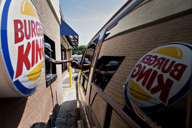 An employee assists a customer at the drive-through of a Burger King in Peoria, Illinois. (Bloomberg)