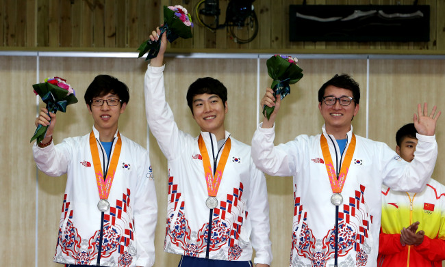 Korea’s Kim Hyeon-jun (from left), Kim Sang-do and Han Jin-seop pose with their silver medals on Tuesday. (Yonhap)