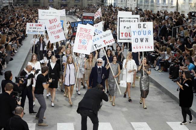 Fashion designer Karl Lagerfeld (center) acknowledges the public along with models faking a demonstation as they present creations for Chanel during the 2015 spring-summer ready-to-wear collection fashion show on Tuesday at the Grand Palais in Paris. (AFP-Yonhap)