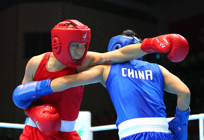 South Korean boxer Park Jin-a (left) won the silver medal in the women’s lightweight class at the Incheon Asian Games on Wednesday, earning the host country its first Asiad medal in the event. In the final held at Seonhak Gymnasium, Park lost to China’s Yin Junhua in a 0-2 decision. (Yonhap0