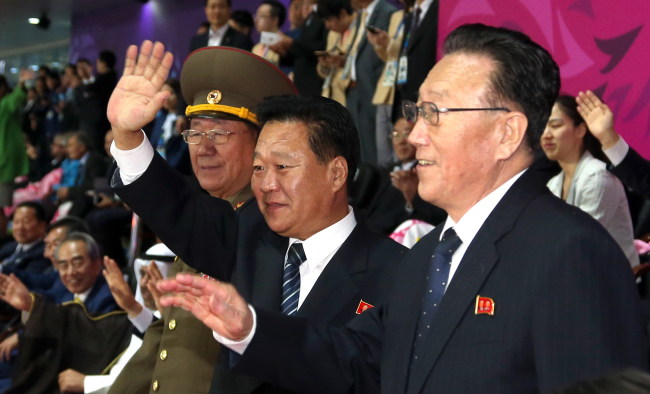 Hwang Pyong-so (from left), head of the North Korean Army’s General Political Bureau; Choe Ryong-hae, secretary of the Worker’s Party; and Kim Yang-gon, veteran official in charge of South Korean affairs, wave to their compatriot participants during the closing ceremony of the 2014 Incheon Asian Games on Saturday. (Yonhap)