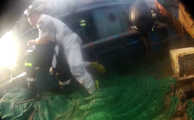 In this screen capture from a video released by the Coast Guard on Saturday, the captain (right) of a Chinese fishing vessel caught for illegal fishing in Korean waters attacks a Coast Guard officer during a raid on Friday, prompting other officers to open fire and resulting in his death. (Coast Guard)