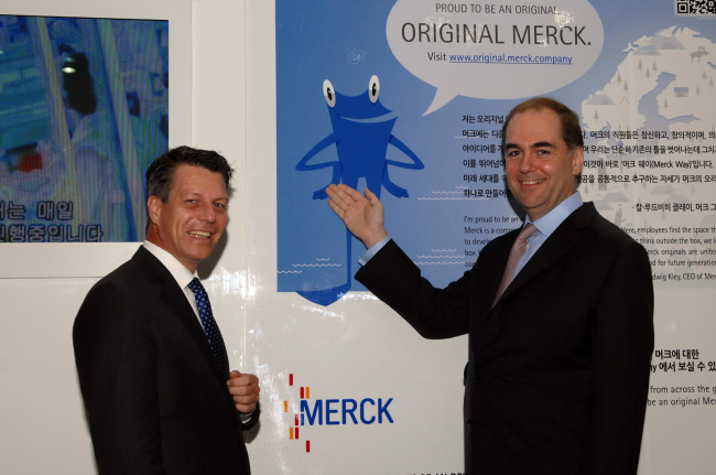 Chairman of the board of partners of E. Merck KG Johannes Baillou (right) poses with Michael Grund, managing director of Merck Korea in front of the Merck Group’s brand campaign poster. (Merck Korea)