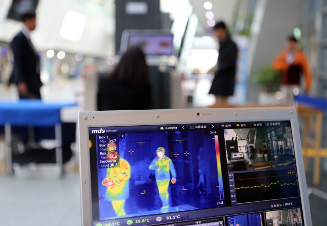 A quarantine officer monitors people’s body temperatures at Busan Exhibition and Convention Center in Busan, where a three-week conference of the International Telecommunication Union is taking place starting Monday. (Yonhap)