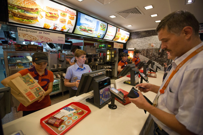 Employees serve customers at the payment counter of a McDonald’s in Moscow. (Bloomberg)