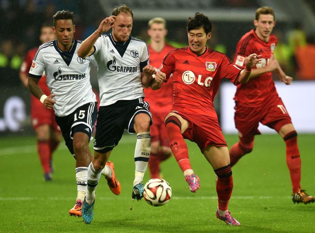 Leverkusen’s Son Heung-min (right) and Schalke’s Benedikt Hoewedes vie for the ball on Saturday. (AFP-Yonhap)