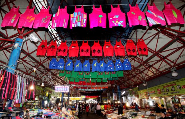 Aprons designed by Dream Gream students and Seoul Art Space Shindang artists hanging from the ceiling of Seoul Jungang Market. (Han Sung Motor)