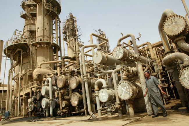 A worker walks past machinery at the al-Doura oil refinery in Baghdad, Iraq. (Bloomberg)