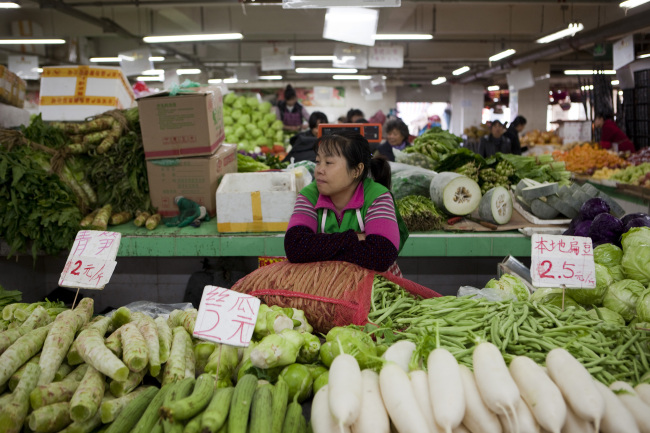 A vendor waits for customers at a market stall in Beijing. (Bloomberg)