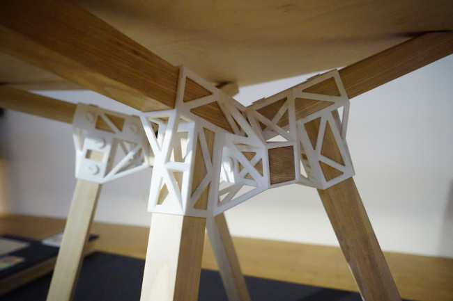 A 3-D-printed connector for the wooden legs of a table by Minale-Maeda