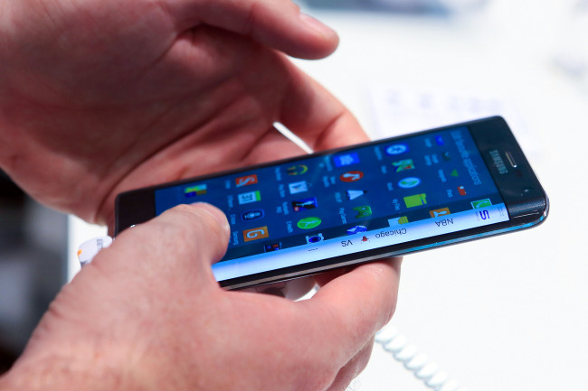 A visitor at the IFA electronics trade show held in Berlin in September tries out the Galaxy Note Edge, which features a curved display on the right side of the device. (Bloomberg)