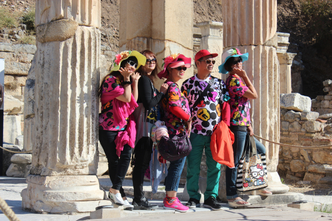 Chinese tourists in bright colors put themselves front and center amid the ruins of Ephesus, Turkey. (Detroit Free Press/MCT)