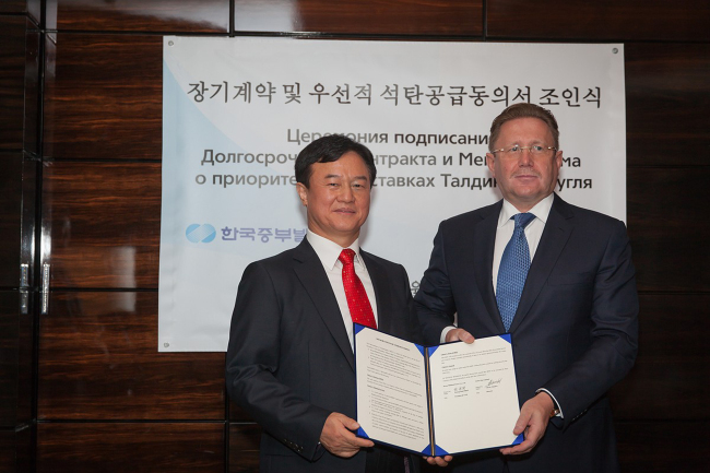 Korea Midland Power Co. CEO Choi Pyeong-rak (left) poses with Alexey Danilov (right), CEO of Carbo One, after signing the deal.