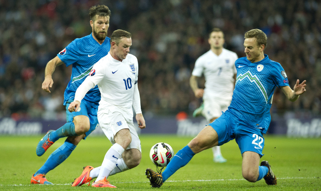 England’s Wayne Rooney (10) and Slovenia’s Boston Cesar (right) vie for the ball on Saturday. (AP-Yonhap)