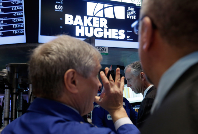 Traders gather at the post that handles Baker Hughes on the floor of the New York Stock Exchange on Monday. (AP-Yonhap)