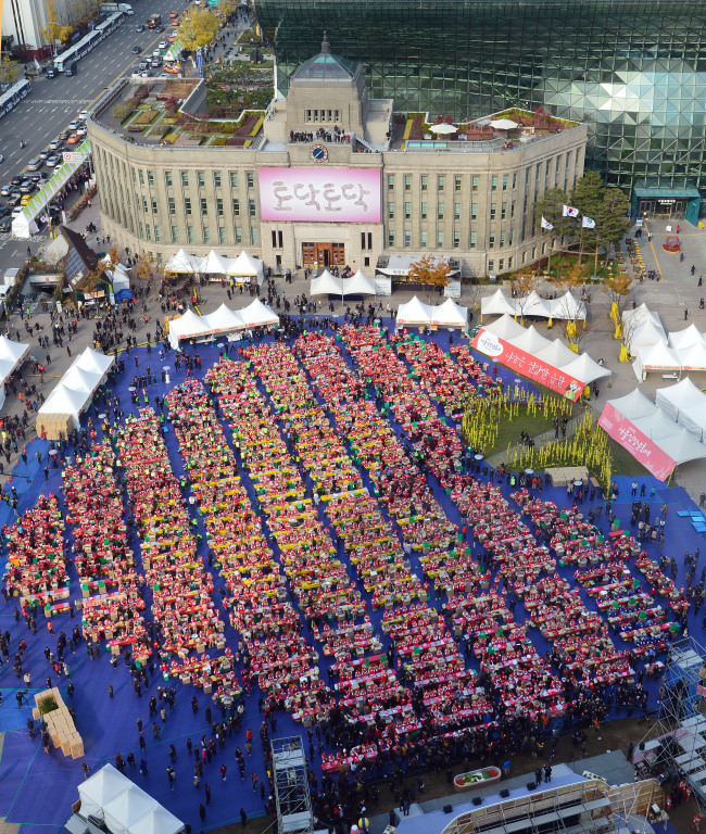 Thousands of people join in an event Friday to make 260 tons of kimchi for underprivileged people. (Yonhap)