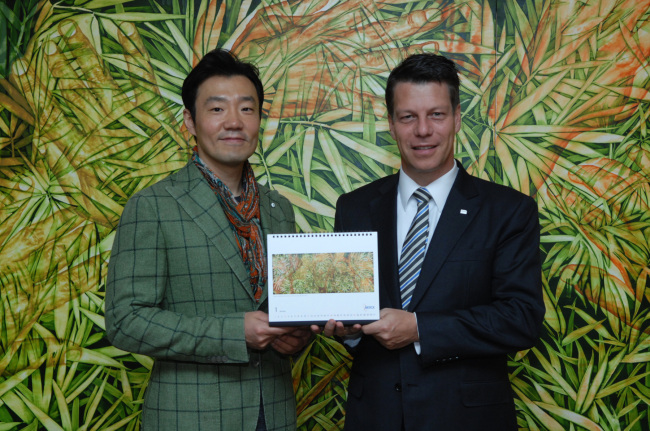 Michael Grund (right), managing director of Merck Korea, poses with Korean painter Kim Geon-il at an event to unveil the company’s 2015 calendar featuring the artist’s paintings in Seoul on Tuesday. (Merck Korea)