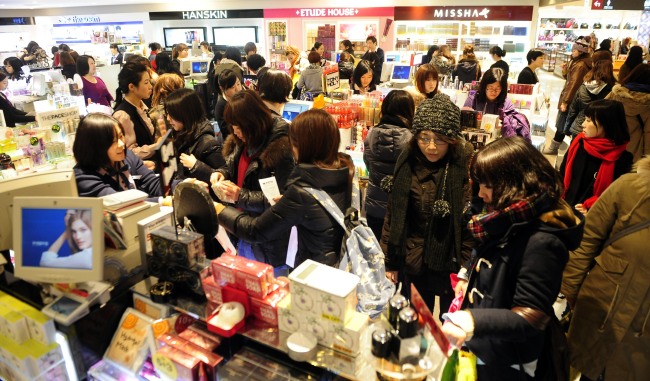 Tourists look around the Lotte Duty Free store in Myeong-dong, Seoul. (Park Hae-mook/The Korea Herald)