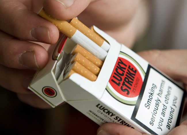 A man selects a Lucky Strike cigarette from a packet. (Bloomberg)