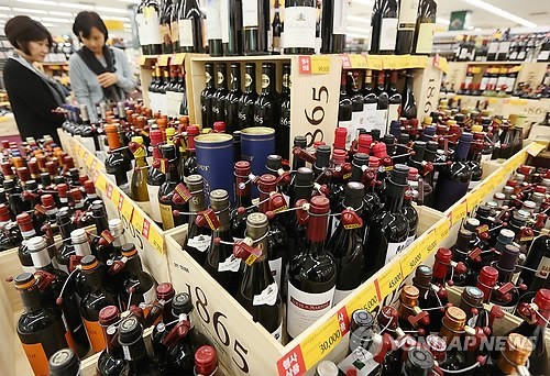 Customers take a close look at a collection of wines in a wine section at a local supermarket chain in Seoul. (Yonhap)