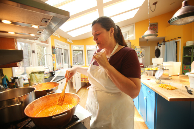 April McGreger of Farmer’s Daughter taste tests a batch of orange marmalade to see if it is ready to be jarred at her Hillsborough, North Carolina, home. (Tribune Content Agency)