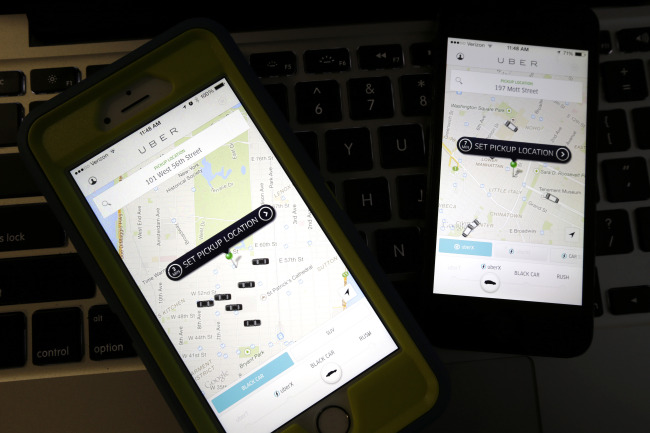 Smartphones display Uber car availability in New York. (AP-Yonhap)