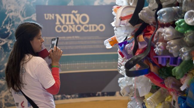 A volunteer takes a picture of a representation of plastics pollution of rivers and oceans that affect the planet in the Ocean Pavilion on the sidelines of the U.N. COP20 and CMP10 conferences in Lima on Wednesday. (AFP-Yonhap)