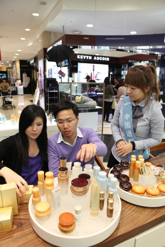 Chinese tourists shop for high-end cosmetics at Lotte Department Store in Myeong-dong, Seoul. (Lotte Department)