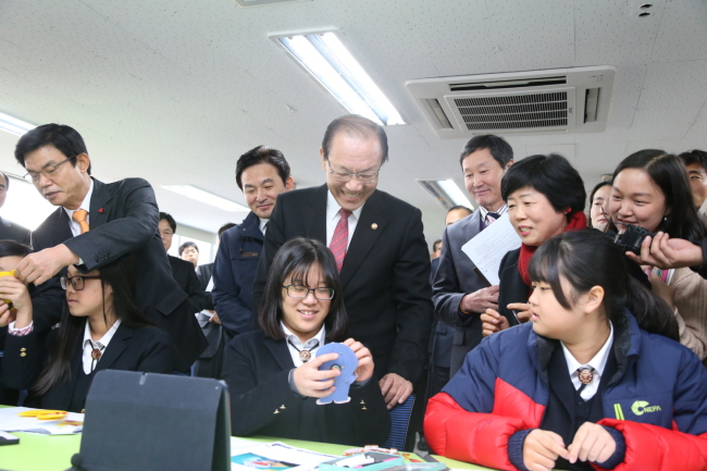 Education Minister Hwang Woo-yea (center, standing) speaks to a first-year middle school student at Seogwi Jungang Girls’ School in Jeju Island on Monday. (Ministry of Education)