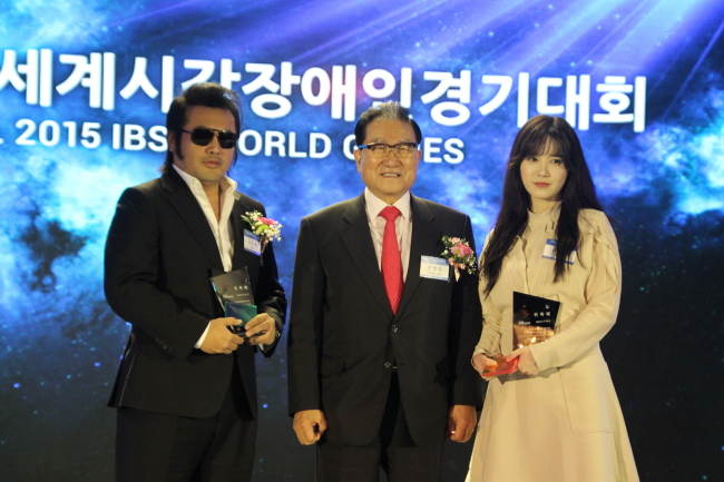 Actor Kim Bo-sung (left) and actress Ku Hye-sun (right) pose with Sohn Byung-doo, president of the Seoul 2015 IBSA World Games organizing committee, after being named goodwill ambassadors for the games in a ceremony at Seoul City Club in Seoul on Tuesday. (Seoul 2015 IBSA World Games)