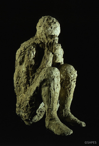 A cast of a sitting man covering his nose and mouth with his hands is among the artifacts on display at the exhibition “Pompeii: The Culture of the Ancient Roman City.” (National Museum)