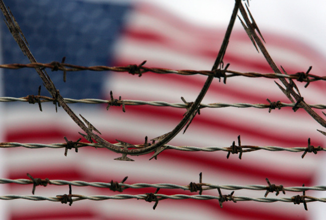 An American flag flies behind the barbed and razor-wire at the Camp Delta detention facility, at Guantanamo Bay U.S. Naval Base, Cuba. (AP-Yonhap)