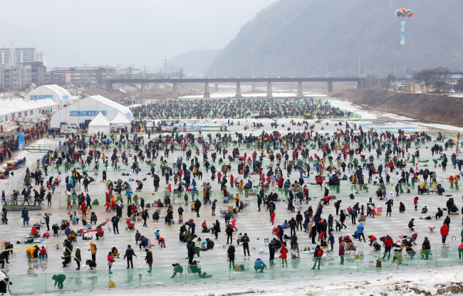 People participate in an annual trout fishing event held as part of a winter festival on Jaraseom Island in Gapyeong, Gyeonggi Province, Sunday. (Yonhap)