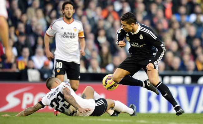 Real Madrid’s Cristiano Ronaldo (right) and Valencia’s Nicolas Otamnedi vie for the ball on Sunday. (AFP-Yonhap)