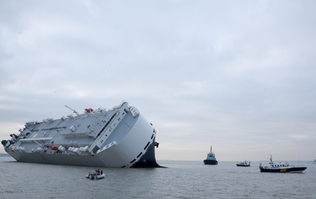 Small boats sail round the Hoegh Osaka car transporter cargo ship that ran aground off the Isle of Wight, England, Sunday. The crew members of the Hoegh Osaka were taken to safety by a coastguard helicopter and lifeboats. (AP-Yonhap)