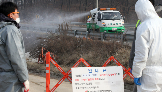 Quarantine officials restrict access to a pig farm where a suspected case of foot-and-mouth disease was detected in Yongin, Gyeonggi Province, Monday. (Yonhap)