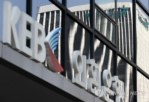 The Hana Financial Group building reflected in the window of a KEB office in Seoul. (Yonhap)