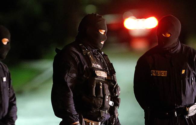 French police stand in the street in Longpont, northern France, on Thursday, local time, during searches as part of an investigation into a deadly attack the day before by armed gunmen on the Paris offices of French satirical weekly Charlie Hebdo. (Yonhap-AFP)