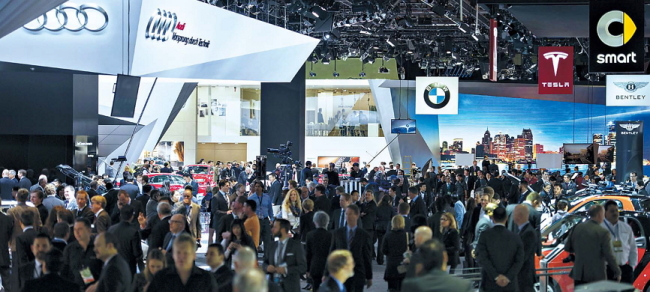 Attendees visit exhibition booths at the 2015 North American International Auto Show in Detroit, Michigan, on Jan. 12. (Bloomberg)