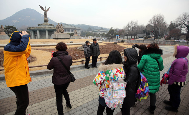 Tourists gather around Cheong Wa Dae in Seoul on Sunday after an anonymous caller threatened to bomb the presidential office. (Yonhap)