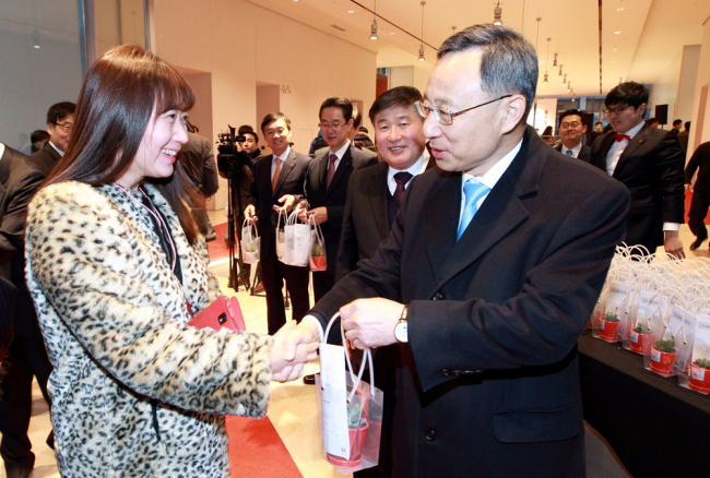 KT CEO and chairman Hwang Chang-gyu (right) hands a flowerpot to an employee to celebrate the opening of the company’s new headquarters building in Gwanghwamun, central Seoul, Monday. (KT)