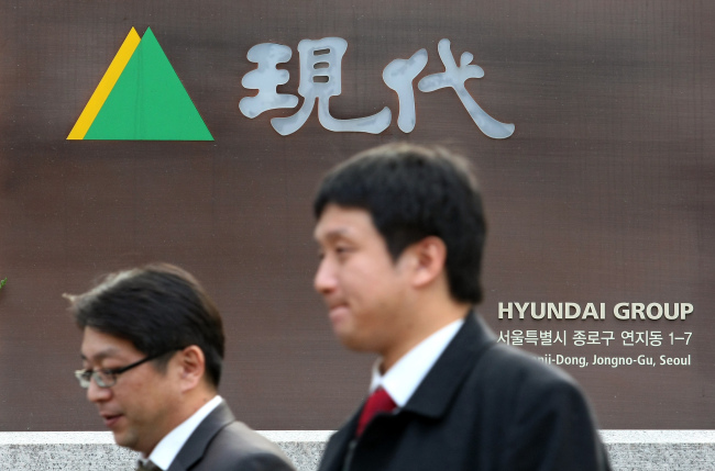 People walk past the logo for Hyundai Group outside the company’s headquarters in Seoul. (Bloomberg)