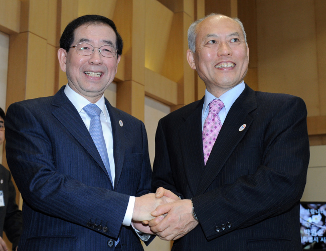 Seoul Mayor Park Won-soon (left) poses with Tokyo Gov. Yoichi Masuzoe during an event to forge a pact on activating mutual interchanges at the Tokyo Metropolitan Government office in Sinjuku district on Tuesday. (Yonhap)