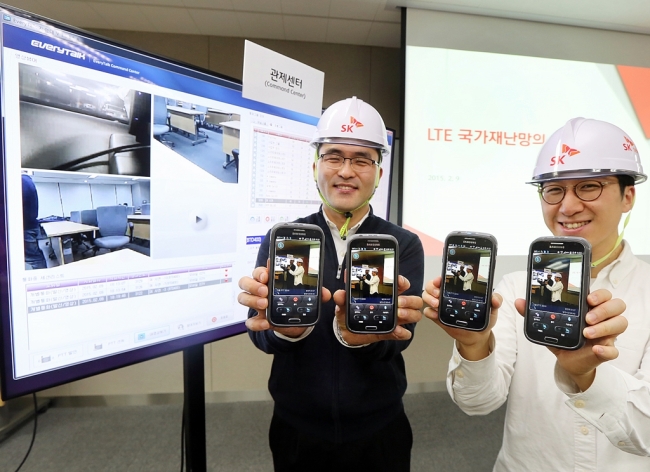 SK Telecom officials pose with gadgets running on the firm’s emergency network system based on Long Term Evolution technology during a media briefing in Seoul on Wednesday. (SK Telecom)